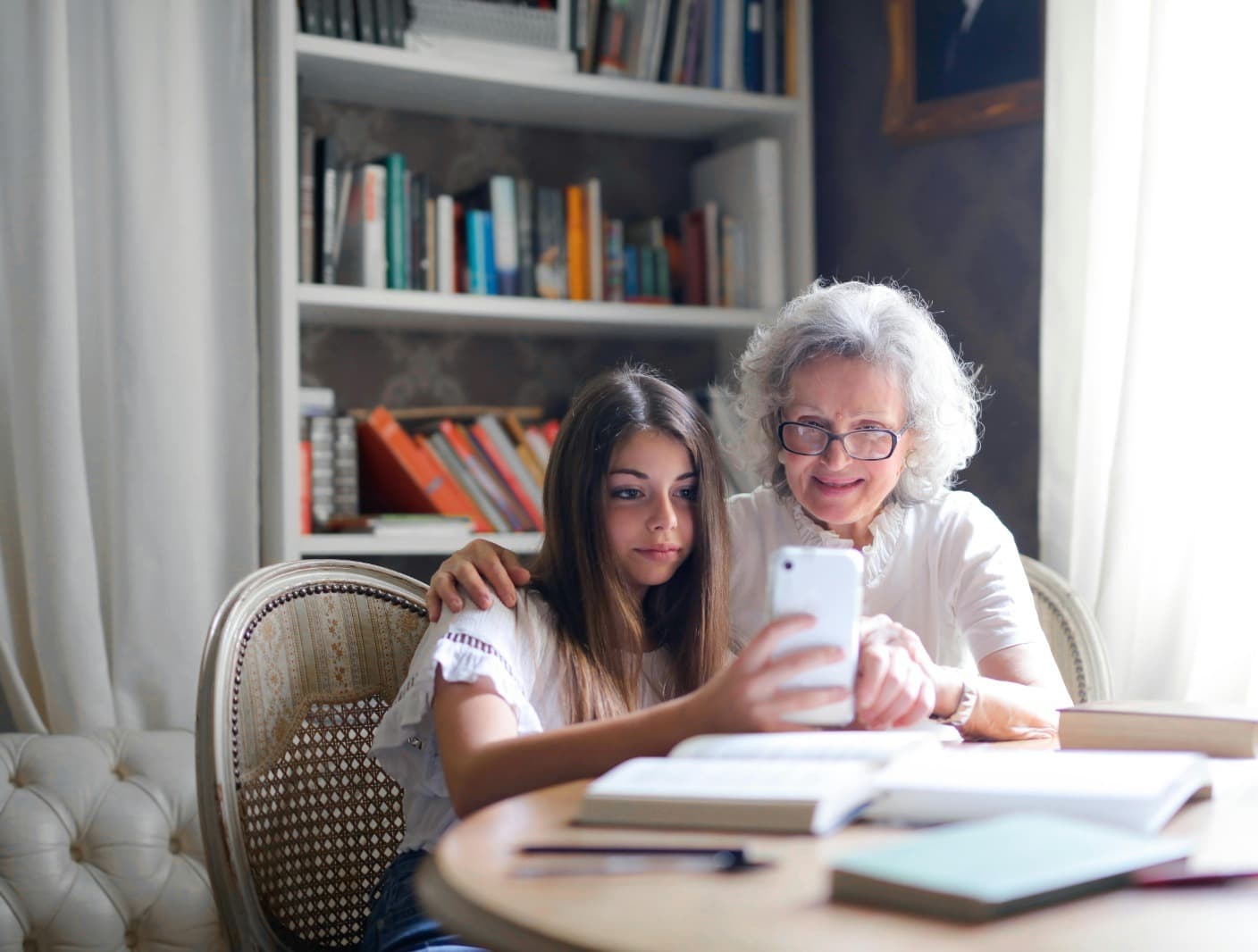 Grandmother showing granddaughter how to use phone
