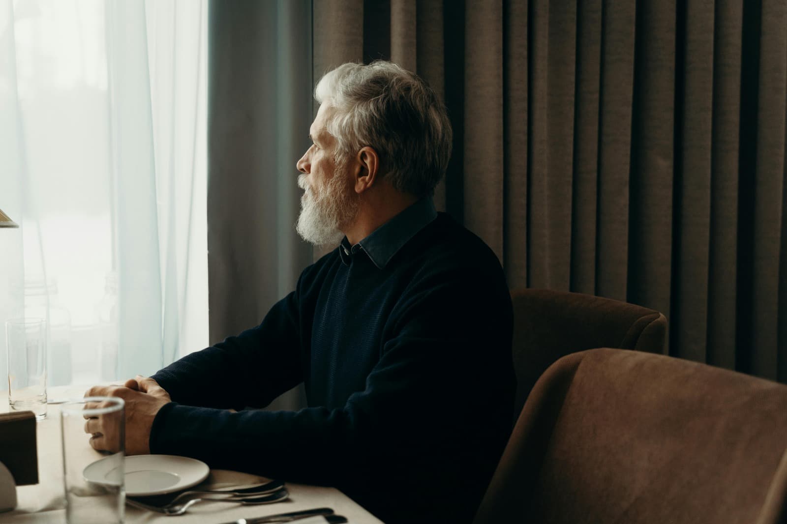 Senior man looking out window